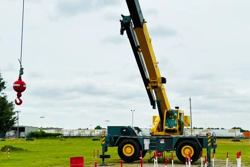 Telescopic mobile crane lifting steel beams on a construction site