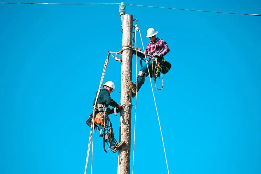 two linemen workers on a telephone pole