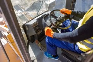 Equipment worker driving industrial vehicle at factory