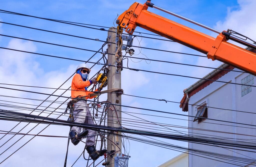 Utility worker works on overhead power lines